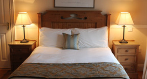 Double room with bedside lamps and wooden furniture